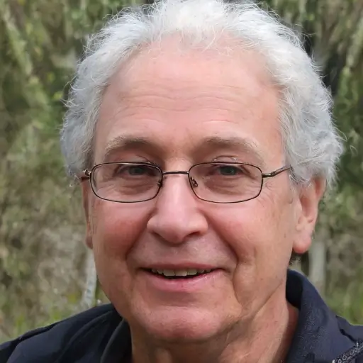Portrait of Martin M., a smiling 73-year-old man with gray hair, who shares his testimonial about reversing his macular degeneration